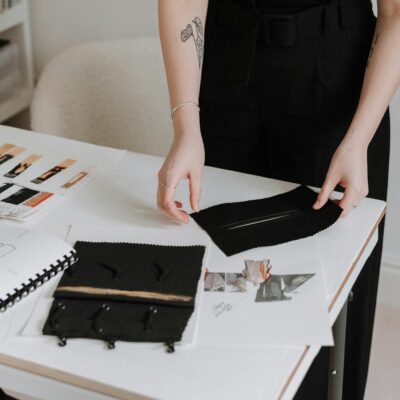 A female designer engaged in exploring fabric samples and sketches in a modern studio.