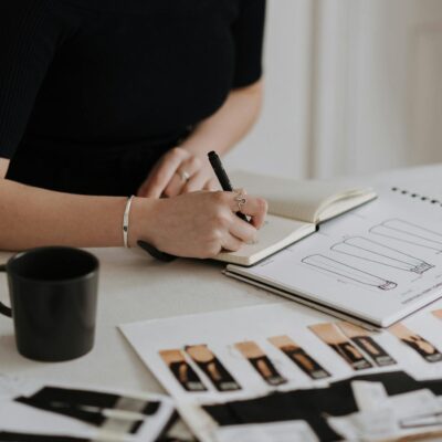 Female designer working on fashion sketches in a creative studio environment.